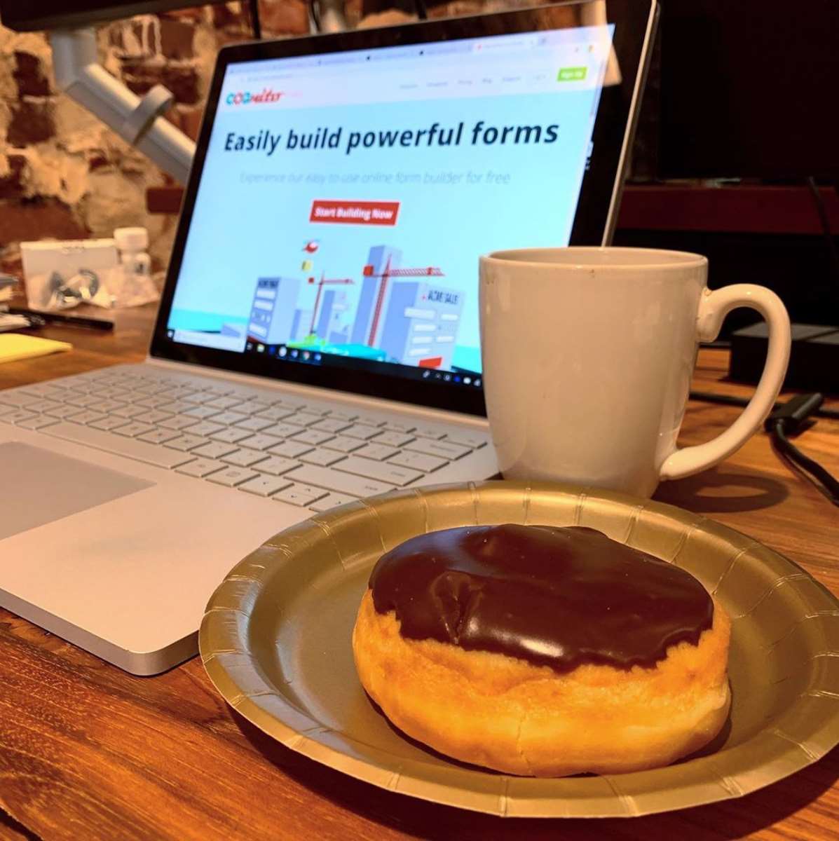 Donut and coffee next to laptop with Cognito's old site